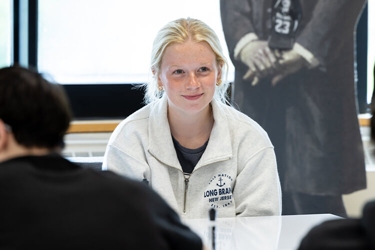 Middle school student participating and smiling in class