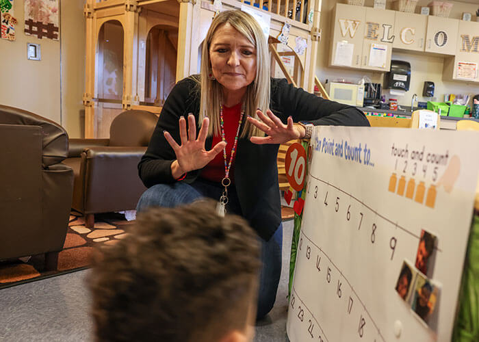 Teacher helps an elementary-aged student count